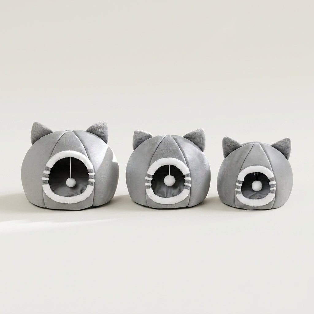 Three gray cat-shaped plush pet houses with ear details and circular openings, arranged in a row on a light beige studio background.