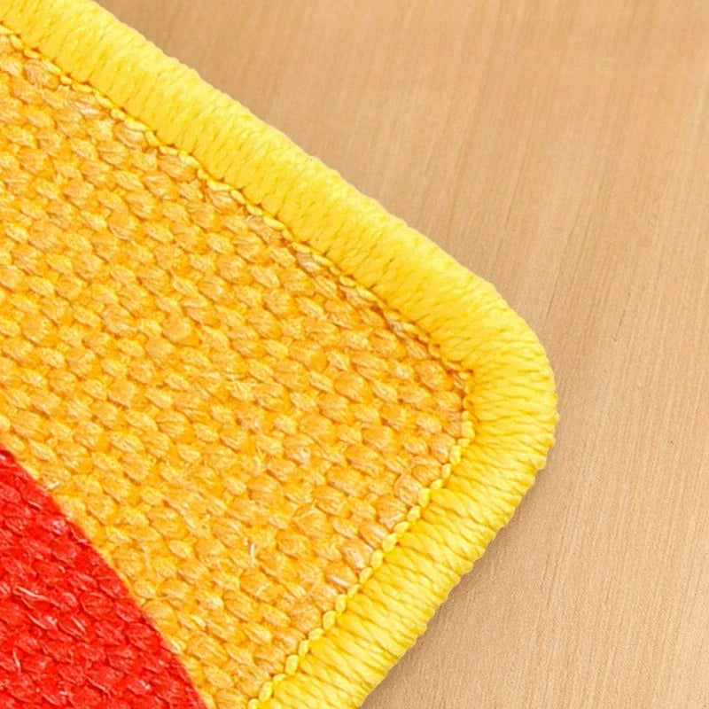 Close-up of a yellow and red textured cat scratch mat on a wooden surface