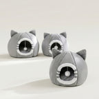 Three gray cat-shaped plush pet houses arranged on a white display riser against a light gray background. The smallest bed is in the foreground.