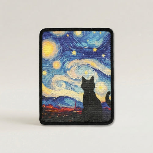 A cat scratch mat with rounded corners, featuring a black cat silhouette in front of a swirling blue, yellow, and white night sky inspired by Van Gogh's Starry Night, finished with a black stitched border.